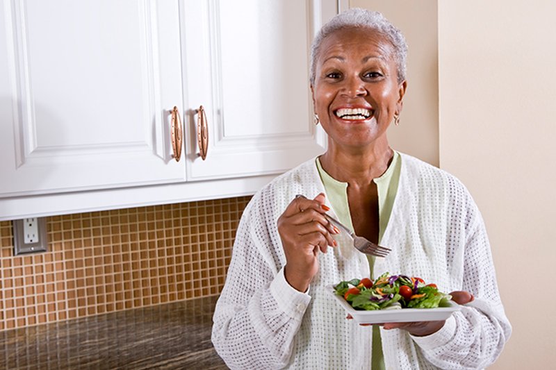 Happy older woman enjoying a balanced, healthy salad